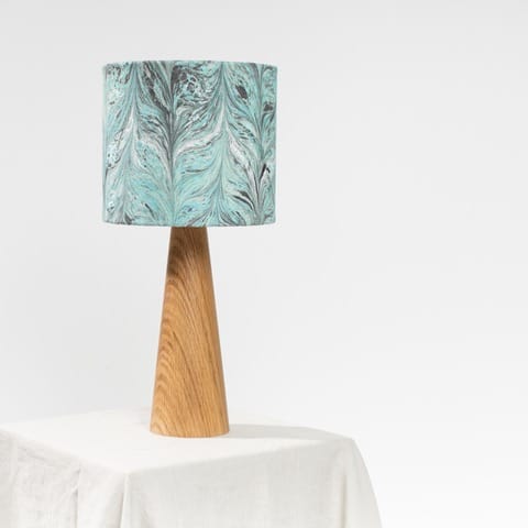Blue marbled lamp shade on table with wooden lamp base
