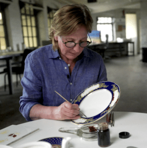 Trainee ceramic artist painting a plate