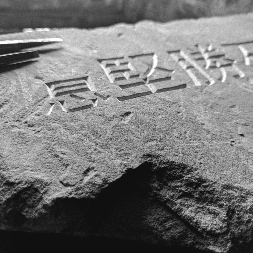 Hand cut Mandarin characters in sandstone