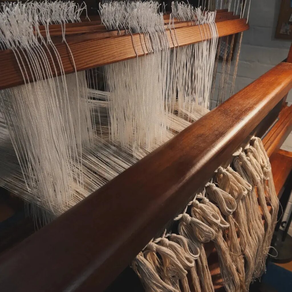 Helde Handweaving Studio vintage wooden floor loom being threaded