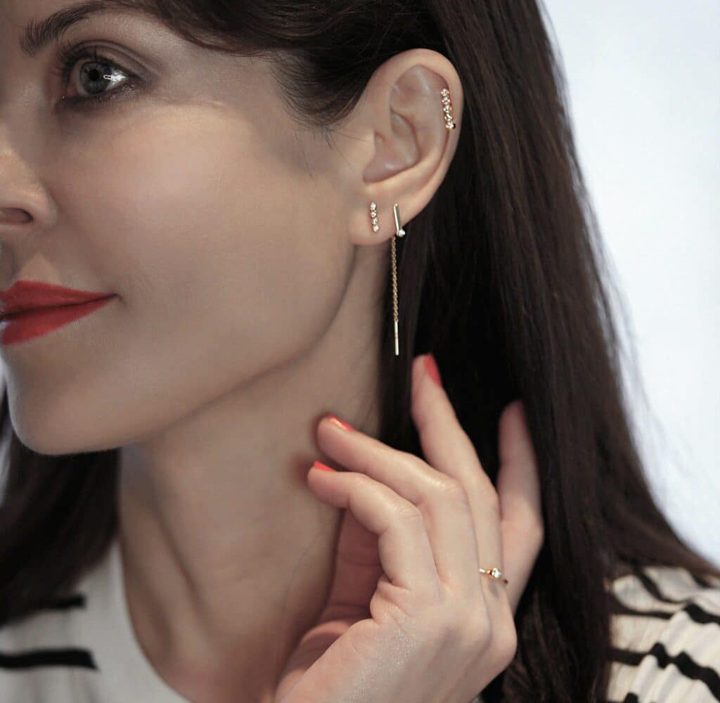 Modern curated ear styling with diamond studs, and minimalist chain earring. Lena Cohen Jewellery London fine handcrafted piercing jewellery.