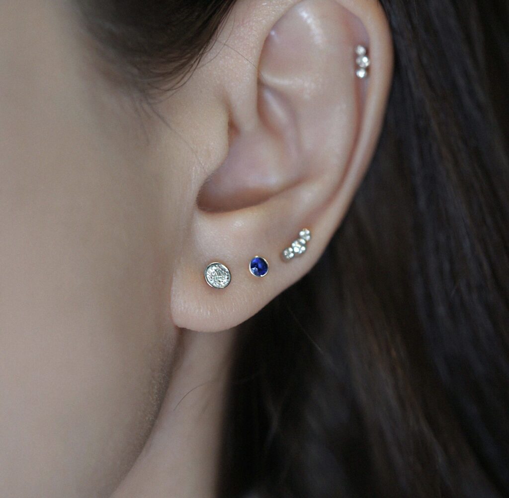 Curated ear styling with diamond studs in 18k gold. Lena Cohen Jewellery London fine piercing earrings.