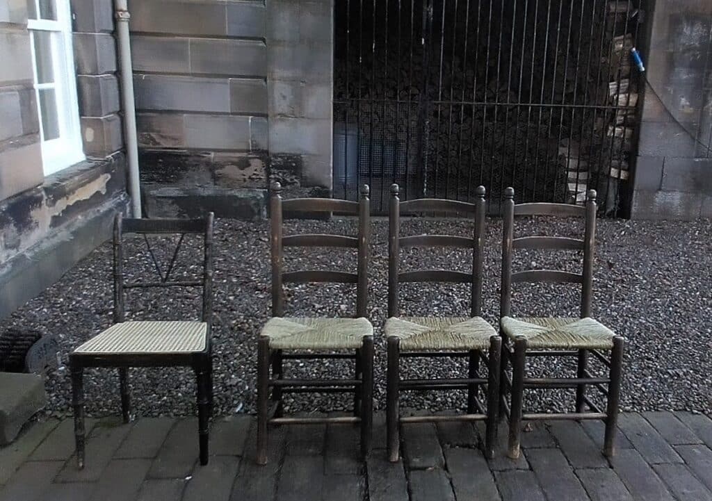 Three rush seated chairs and a cane chair.